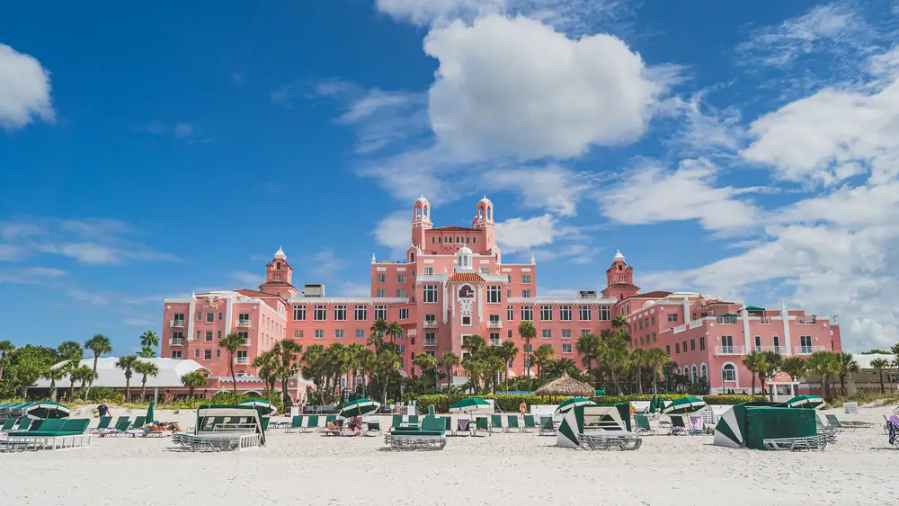 The pink Don CeSar hotel on St. Pete Beach under a blue sky with palm trees