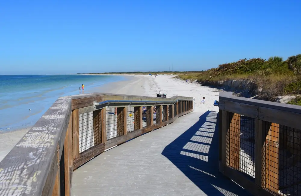 Wooden boardwalk leading over the dunes to a white-sand Gulf beach